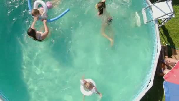 Luchtopname van kinderen die zwemmen in het blauwe ronde zwembad — Stockvideo