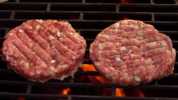 Zbliżenie dwóch soczystych kotletów mięsnych z cebulą pieczonych nad ogniem — Wideo stockowe