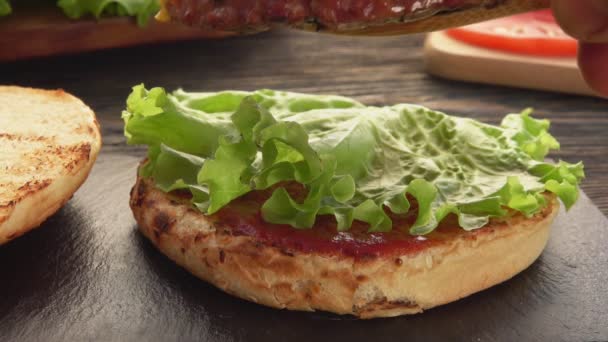 Close-up da costeleta de carne grelhada com queijo colocado no topo do hambúrguer — Vídeo de Stock