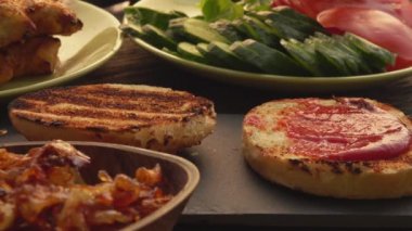 Ellerinizi yakın plan yapın ve ızgara tavuk filetosunu ekmeğin üzerine koyun.