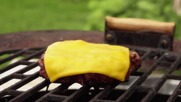 Nahaufnahme des saftigen Burger-Schnitzels mit Cheddar-Käse am offenen Feuer braten — Stockvideo