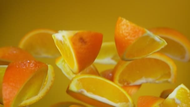 Fatias deliciosas frescas de laranja madura estão voando sobre o fundo amarelo — Vídeo de Stock