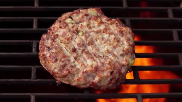 Primer plano de la jugosa chuleta de hamburguesa de carne con cebollas asadas sobre una fogata abierta — Vídeo de stock