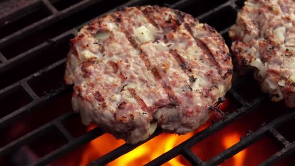 Super gros plan de l'escalope de hamburger de viande juteuse avec des oignons frits au-dessus d'un feu — Video