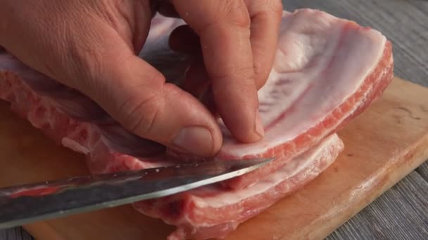 Close-up das mãos masculinas cortando o filme gorduroso das costelas cruas — Vídeo de Stock
