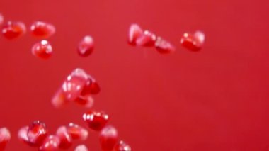 Sulu nar taneleri kırmızı arka planda yükselip alçalıyor.