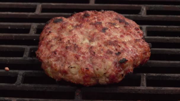 Close-up of the meat cutlet with onions flipped with kitchen spatula on a grill — Stock Video