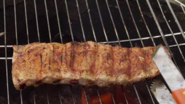 Lezzetli kaburgalar, arka plandaki ızgara ızgarasında döner.