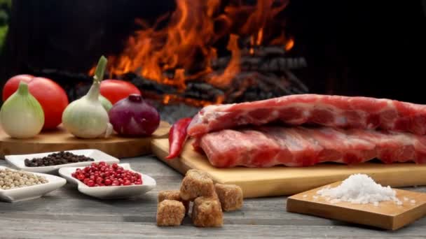 Costillas crudas colocadas en el tablero de madera junto a los ingredientes para la preparación — Vídeo de stock