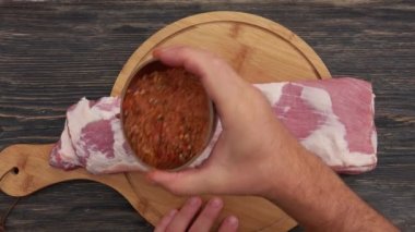 Erkek ellerinin üst görüntüsü çiğ kaburgaları baharatla tatlandırıyor.