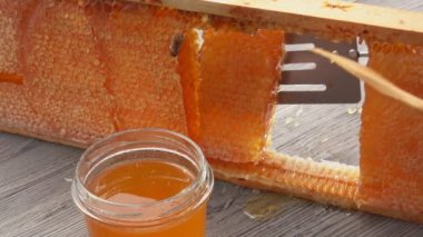 Balpeteklerinin bir kısmı ahşap çerçeveden mutfak spatulasıyla alınır. 