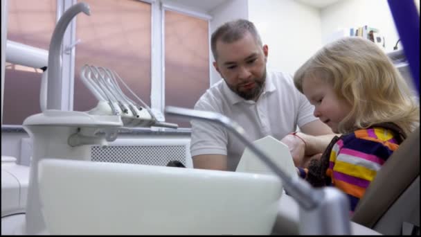 La bambina sta imparando a pulirsi i denti con l'aiuto del dentista — Video Stock