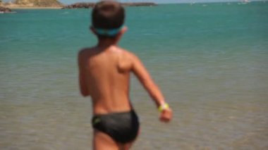 Çocuk deniz su sıçramalarına ile çalışır