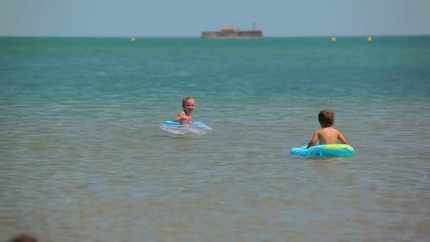 Enfants dans la mer avec anneau gonflable — Video