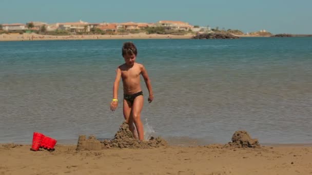 ビーチで水にジャンプの少年 — ストック動画