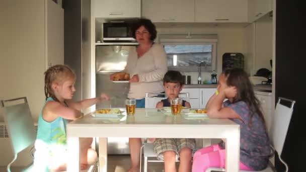 Дети едят курицу с картошкой — стоковое видео