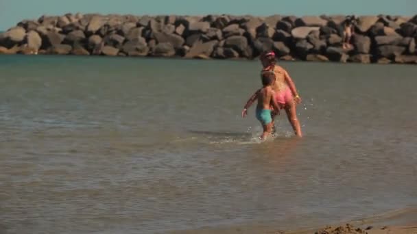 Щасливі діти біжать навколо на пляжі — стокове відео