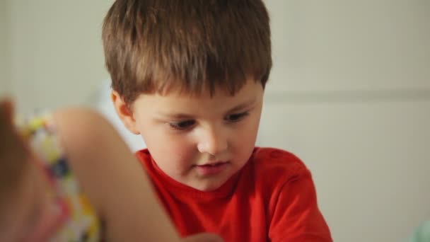 Мальчик рисует карандаши на бумаге — стоковое видео