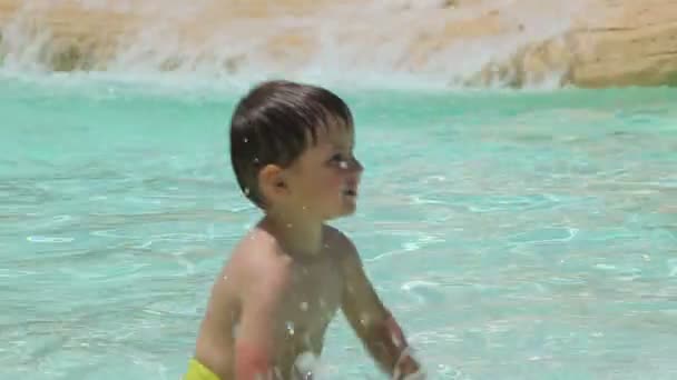 Chico salpicadura de agua en la piscina — Vídeo de stock