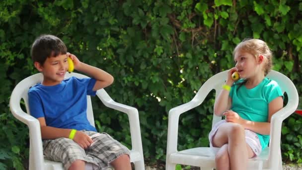 Boy and girl plays with a banana like a phone — Stock Video