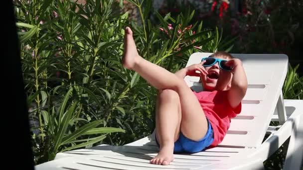 Niño jugando con gafas de sol — Vídeos de Stock