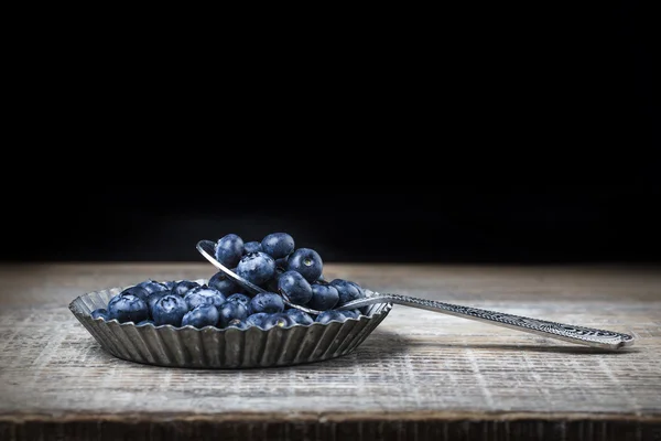 Blueberry, fruit, blue, spoon, wood, black background, beads, iron plate — Stock Photo, Image