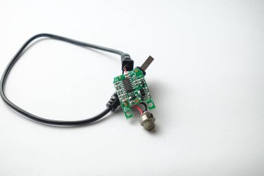 Yakın çekim bir kabloya bağlı devre kartını yakalar, ayrıntılı bileşenleri ve bağlantılarını gösterir. Bu sahne modern teknoloji ve mühendisliğin güzelliğini vurgular..