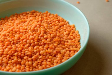 Canlı turuncu mercimekler turkuaz bir kasede güzelce düzenlenir. Parlak ve neşeli mutfağa sıcak, davetkar bir dokunuş sunulur. Bu sahne besleyici bir yemeğe hazırlanmamızı öneriyor..