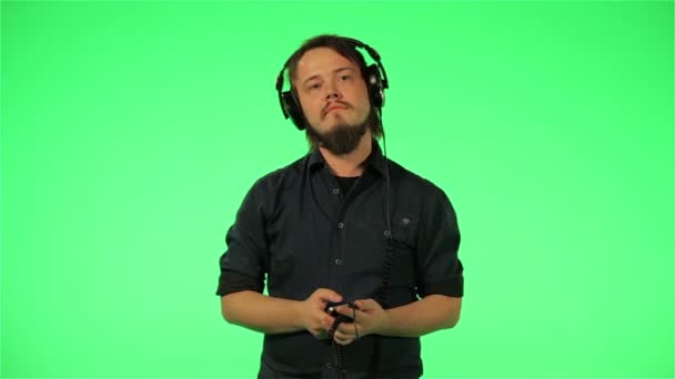 Человек слушает музыку по телефону на зеленом экране Стоковый Видеоролик
