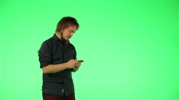 Jonge kerel met uw telefoon op groen scherm — Stockvideo