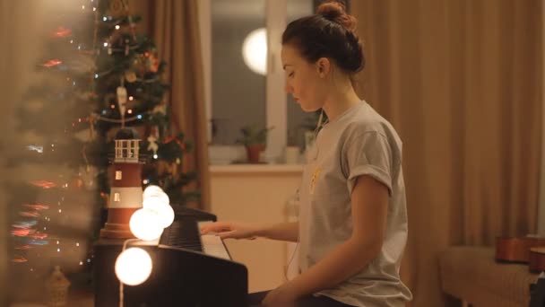 Молодая девушка играет на пианино в доме — стоковое видео