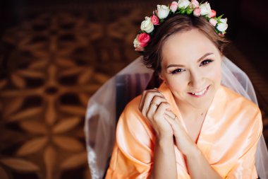 Beautiful bride with wreath of flowers in her hair preparing. Wedding day.