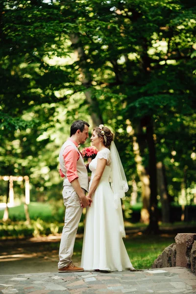 Bride and groom at wedding Day walking Outdoors on green nature. — Stock fotografie