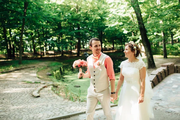 Novia y novio en el día de la boda caminando al aire libre en la naturaleza verde . — Foto de Stock