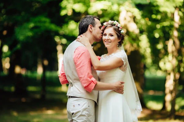 Bruid en bruidegom op de bruiloft dag heerlijk knuffelen buitenshuis op groene natuur. — Stockfoto