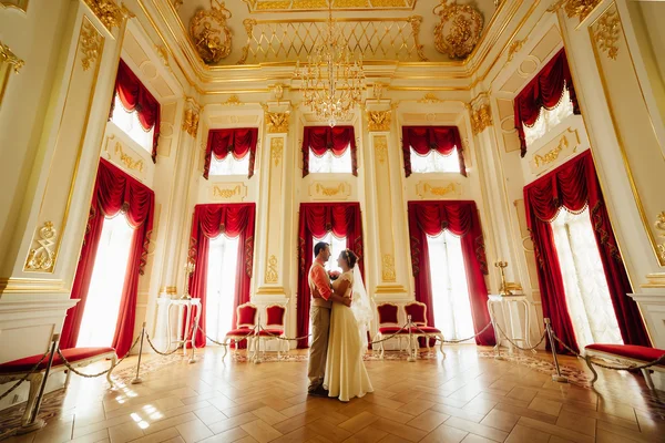 Casal elegante feliz no fundo interior luxuoso do castelo incrível . Fotografias De Stock Royalty-Free