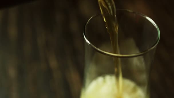 A sötét fából készült asztal pohárba öntjük a sör — Stock videók