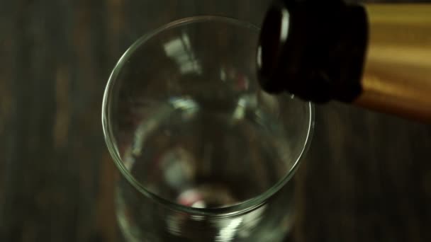 Giet bier in een glas op houten tafel. Bovenaanzicht — Stockvideo