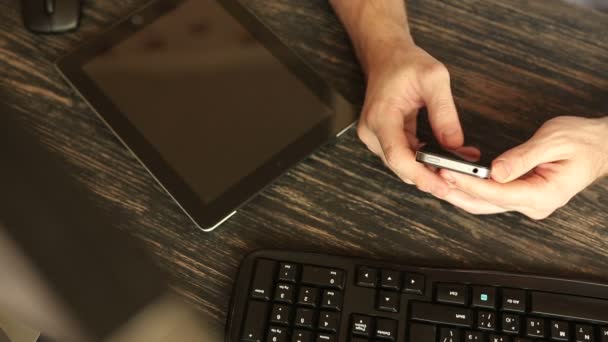 Primer plano de manos con teléfono móvil en escritorio de madera — Vídeos de Stock