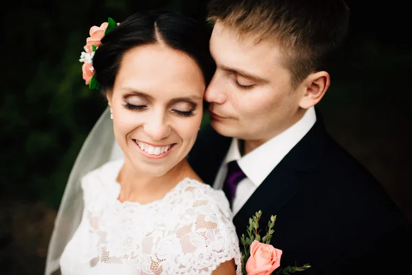 Elegante novio elegante abraza con su novia feliz en el parque — Foto de Stock