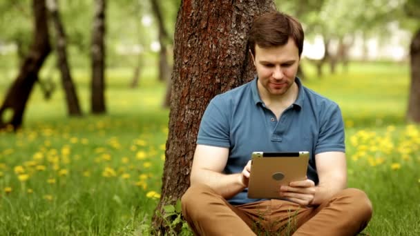 Schöner Hipster-Mann mit seinem Tablet-PC an einem sonnigen Tag — Stockvideo