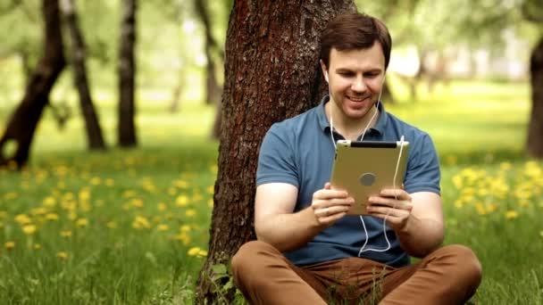 Yakışıklı hipster adamla konuşmak güneşli bir günde onun tablet PC'yi kullanma — Stok video