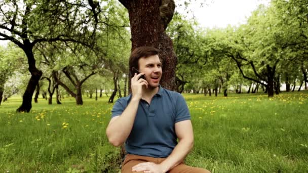 Knappe hipster man praten over telefoon op een zonnige dag — Stockvideo