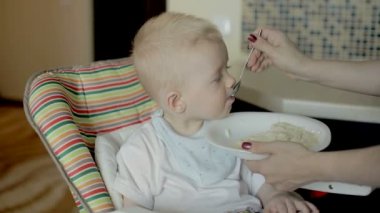 Anne, bebeği evde besliyor.