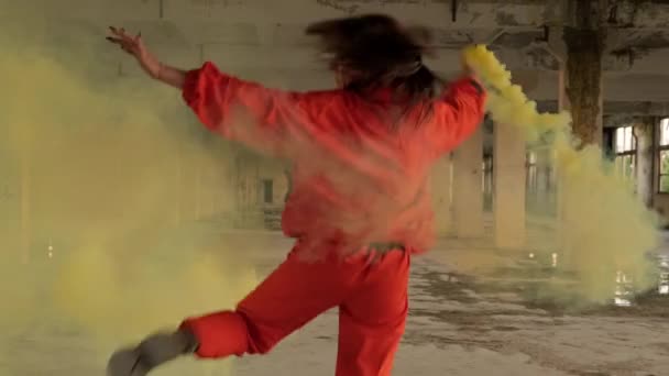 Terk edilmiş fabrikada elinde dumanla dans eden şık bir kadın. Serbest dans — Stok video