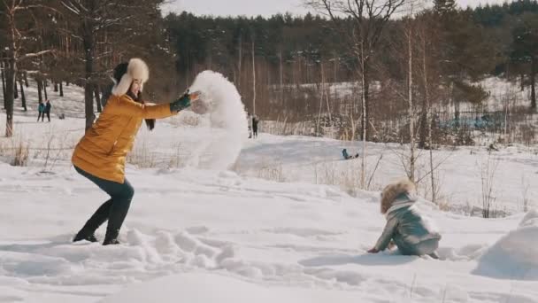 Mutter spielt mit Tochter im Slomo Schnee. Familie hat Spaß an sonnigem Wintertag — Stockvideo