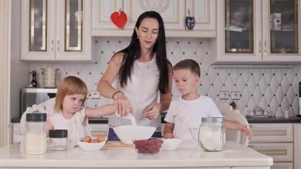 Childs com a mãe preparando massa na cozinha. Mãe com pequeno filho e filha — Vídeo de Stock