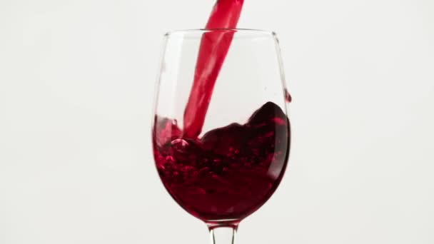 Häll rödvin i bägaren. Närbild av att fylla vinglas med rött vin — Stockvideo