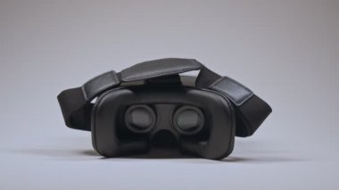 Erkek eli VR gözlüklerini alır ve beyaz arka planda takar..