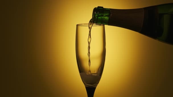 Champagne gieten in glas op gele achtergrond. Feestconcept. Uitgaansleven — Stockvideo